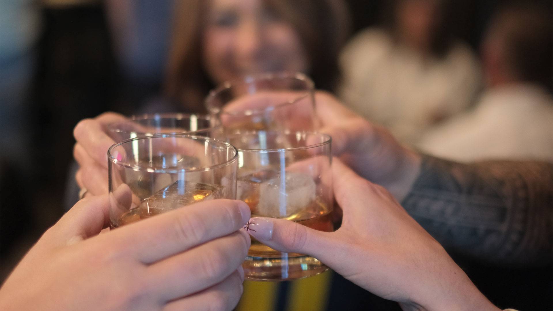 Group of people toasting with Sons of Mitch's whiskey in glass