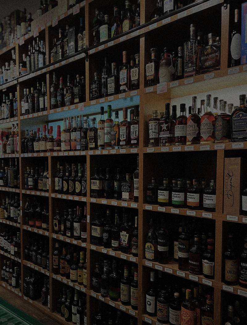 Shelves full of whiskey bottles in a liquor store where you can find Sons of Mitch's Tennessee Whiskey